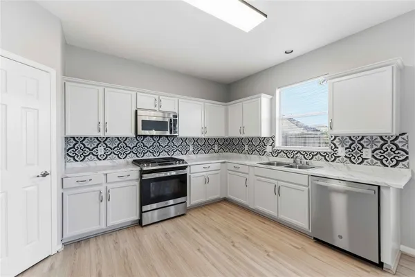 a kitchen with granite countertop white cabinets and white appliances