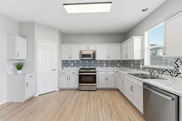 a kitchen with granite countertop white cabinets and white appliances