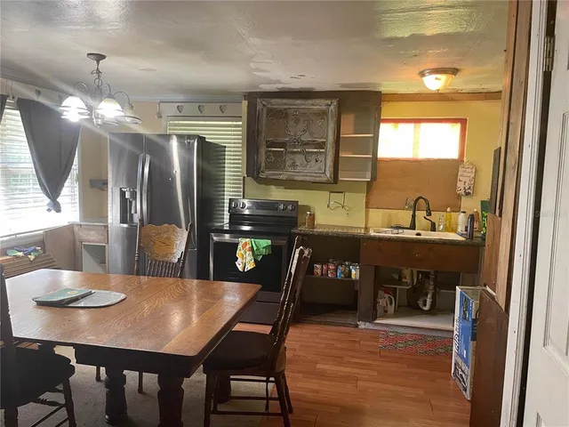 a kitchen with stainless steel appliances kitchen island granite countertop a dining table chairs and granite counter tops