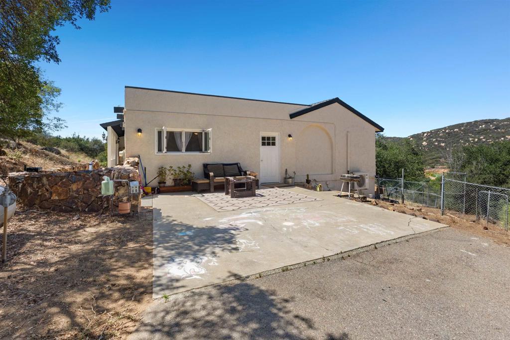 3340 Skytrail Ranch Road Jamul, CA 91935 - Photo 28 of 38 a backyard of a house with table and chairs under an umbrella