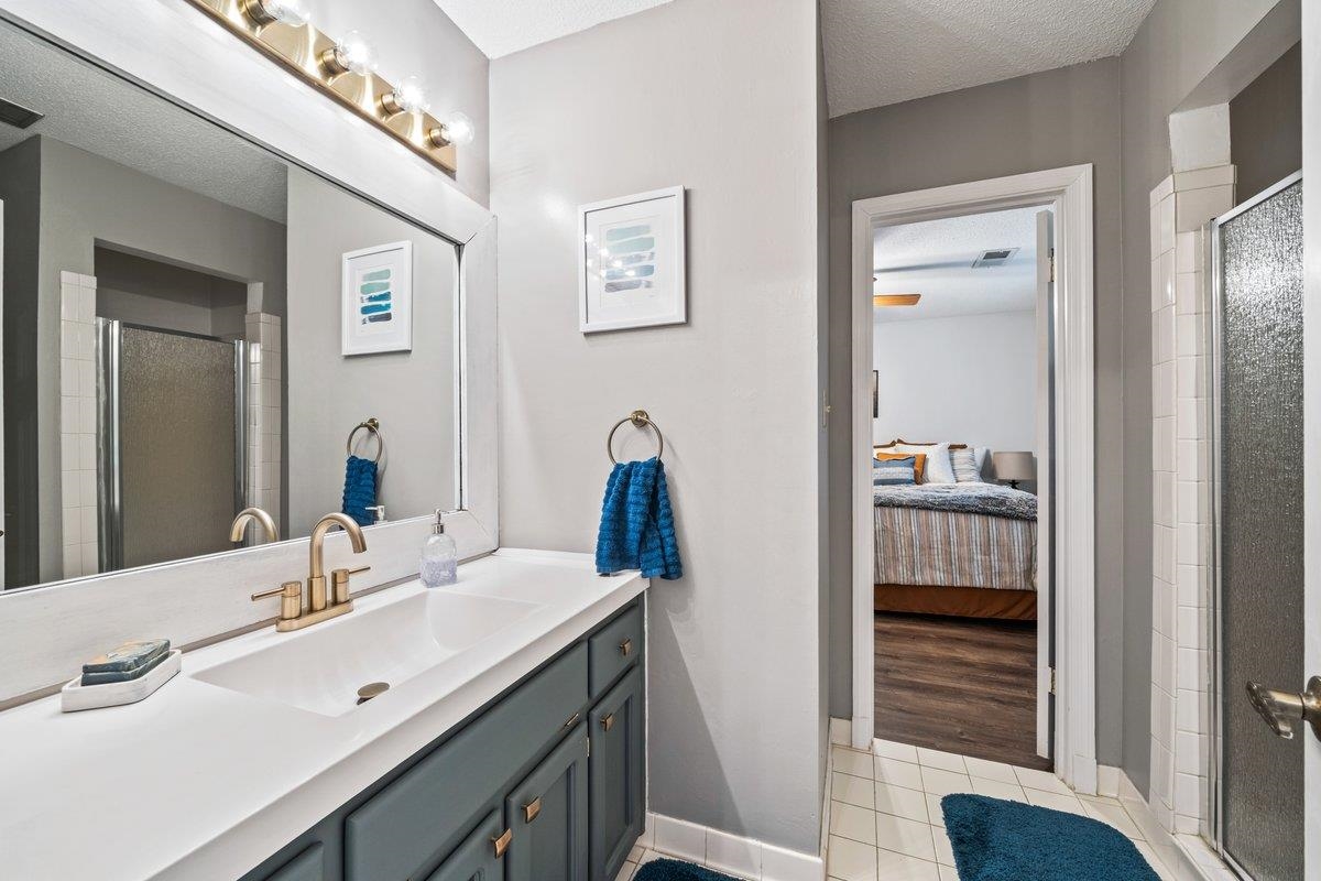 2135 Brierbrook Road Germantown, TN 38138 - Photo 16 of 25 Ensuite bathroom featuring a stall shower, vanity, a textured ceiling, and light tile patterned floors