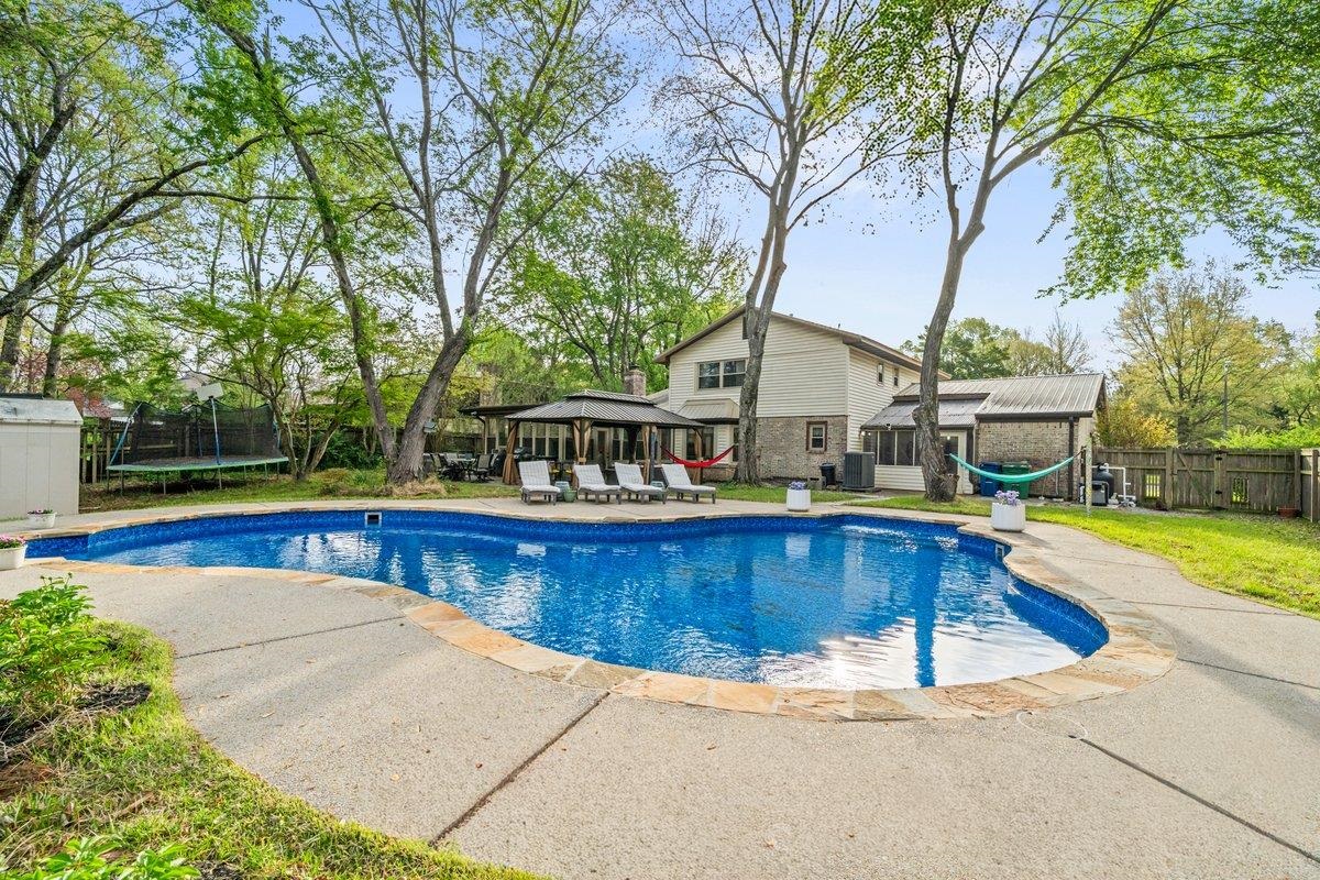 2135 Brierbrook Road Germantown, TN 38138 - Photo 23 of 25 View of pool featuring a gazebo, a trampoline, patio surround, a fenced backyard, and an outdoor structure