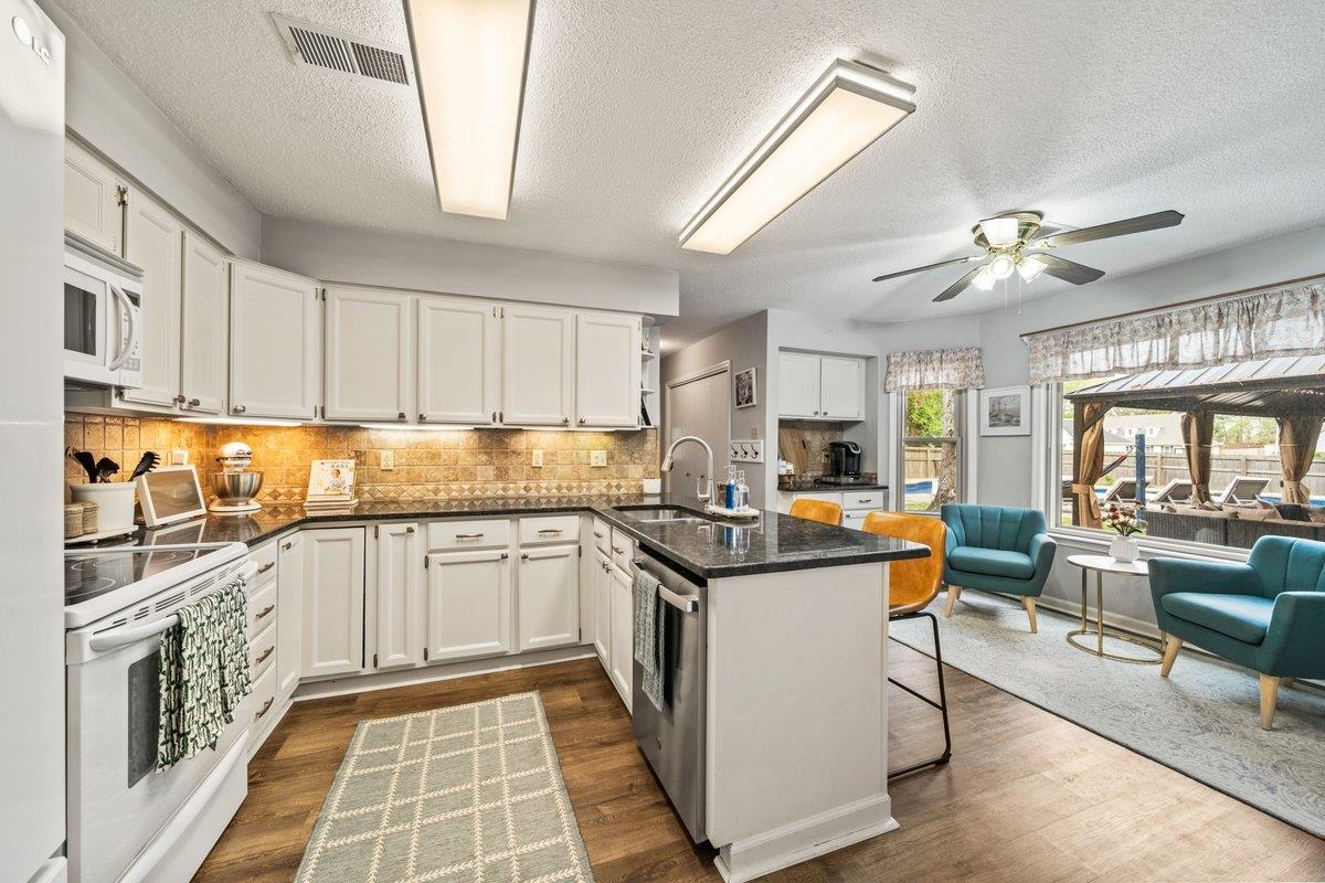 2135 Brierbrook Road Germantown, TN 38138 - Photo 25 of 25 Kitchen featuring a peninsula, white appliances, white cabinetry, a breakfast bar, and open floor plan