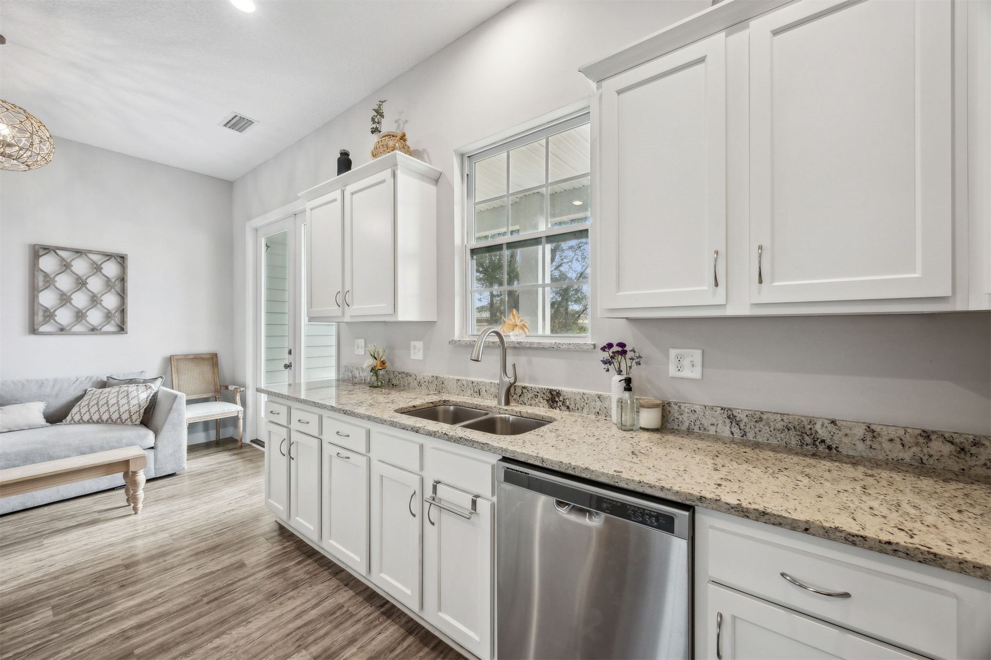96718 Blackrock Road Yulee, FL 32097 - Photo 24 of 54 a kitchen with a sink dishwasher and white cabinets with wooden floor