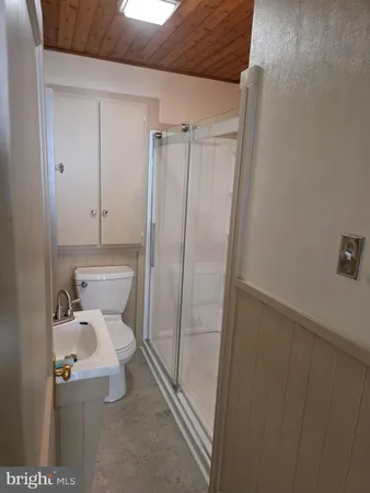 a white toilet sitting next to a shower