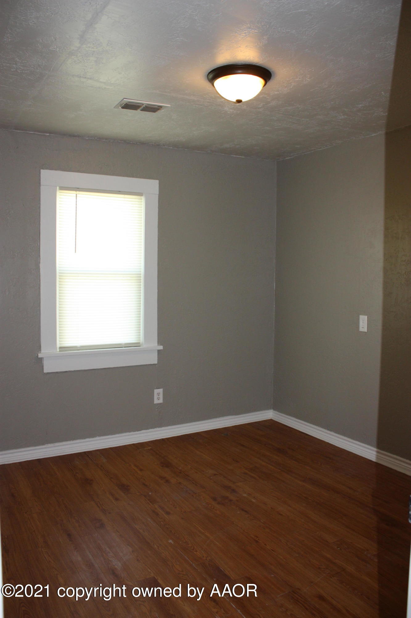 3905 South Tyler Street Amarillo, TX 79110 - Photo 12 of 35 a view of an empty room with wooden floor and a window