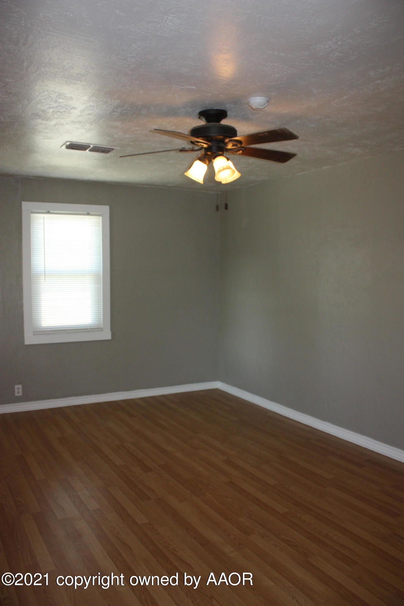 3905 South Tyler Street Amarillo, TX 79110 - Photo 35 of 35 an empty room with wooden floor chandelier fan and windows