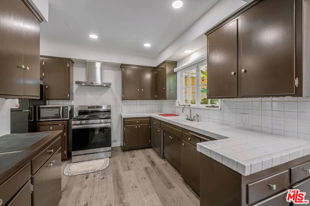2841 Roscomare Road Los Angeles, CA 90077 - Photo 11 of 28 a kitchen with stainless steel appliances granite countertop a sink stove and refrigerator