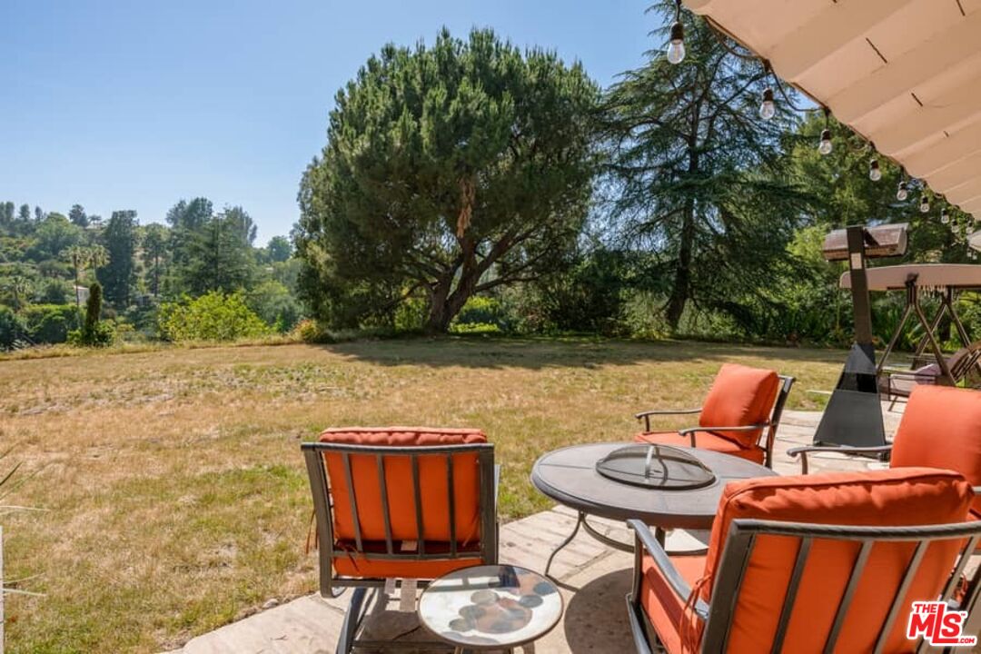 2841 Roscomare Road Los Angeles, CA 90077 - Photo 27 of 28 a backyard of a house with table and chairs