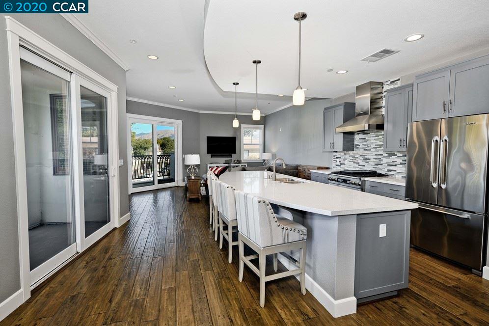 a kitchen with stainless steel appliances a stove a refrigerator a oven and white cabinets with wooden floor