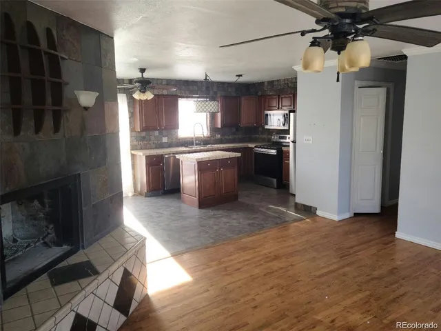 a kitchen with kitchen island a counter top space a sink stainless steel appliances and cabinets