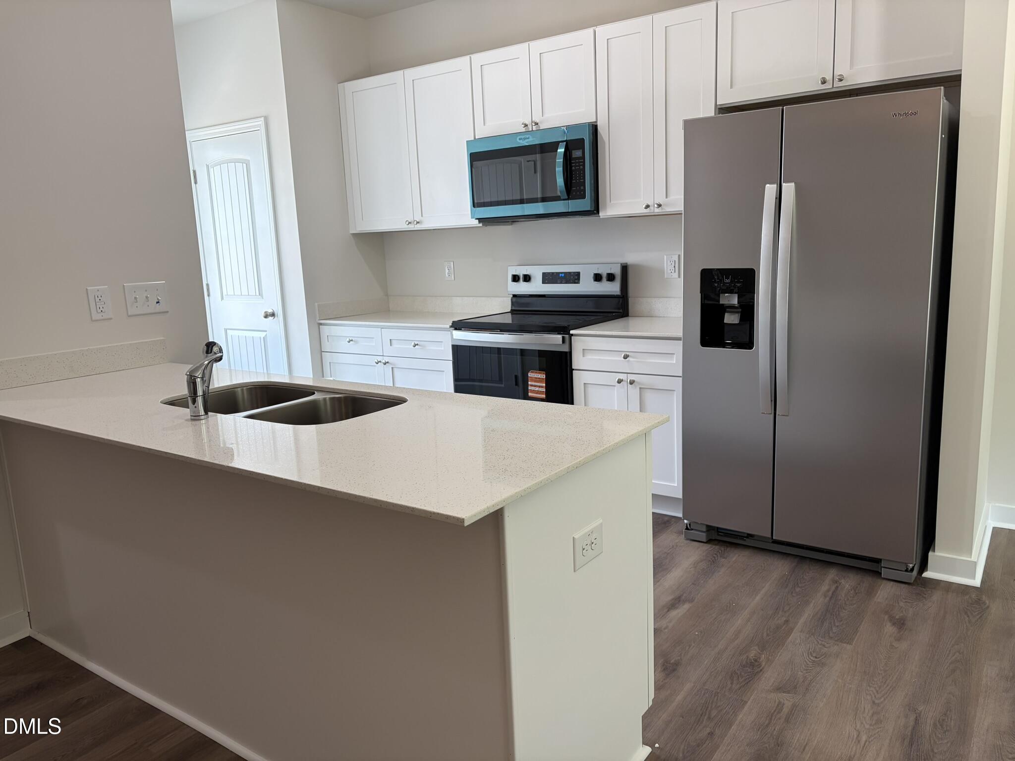 56 Jacobs Ridge Drive Four Oaks, NC 27524 - Photo 3 of 19 a kitchen with a refrigerator a stove a microwave and cabinets