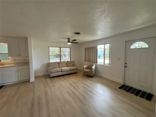 a living room with furniture and a hard wood floor