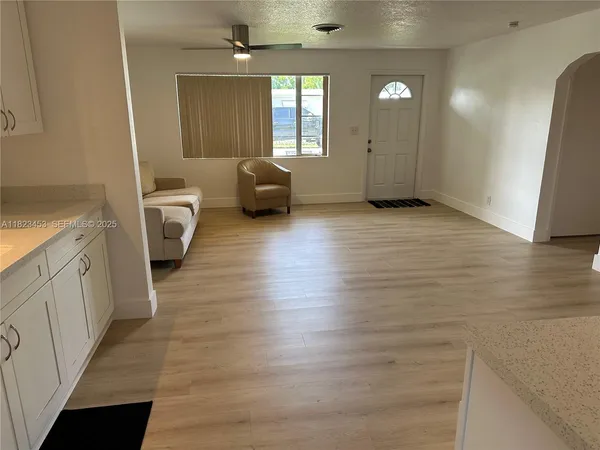 a view of a kitchen with furniture and wooden floor