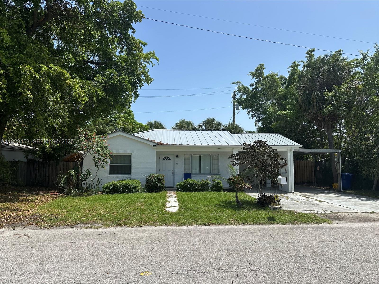 201 East 28th Street Riviera Beach, FL 33404 - Photo 2 of 27 a front view of a house with a yard and garage
