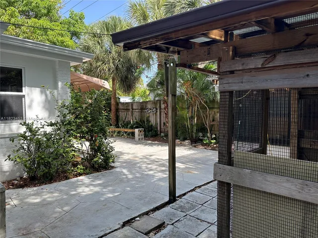 a patio with table and chairs and potted plants