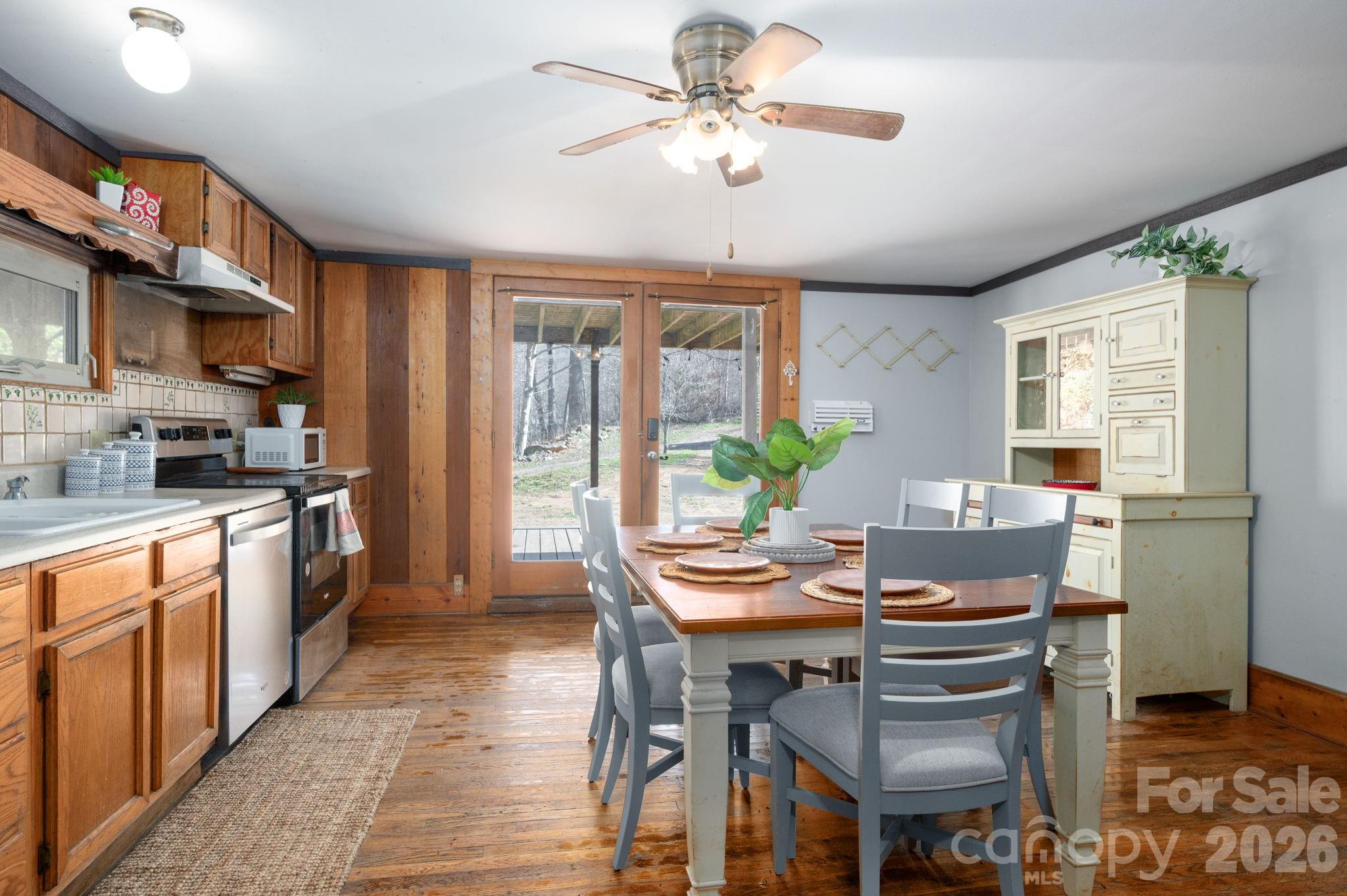 1265 Dillingham Road Barnardsville, NC 28709 - Photo 12 of 46 a kitchen with a dining table chairs stainless steel appliances cabinets and a potted plant