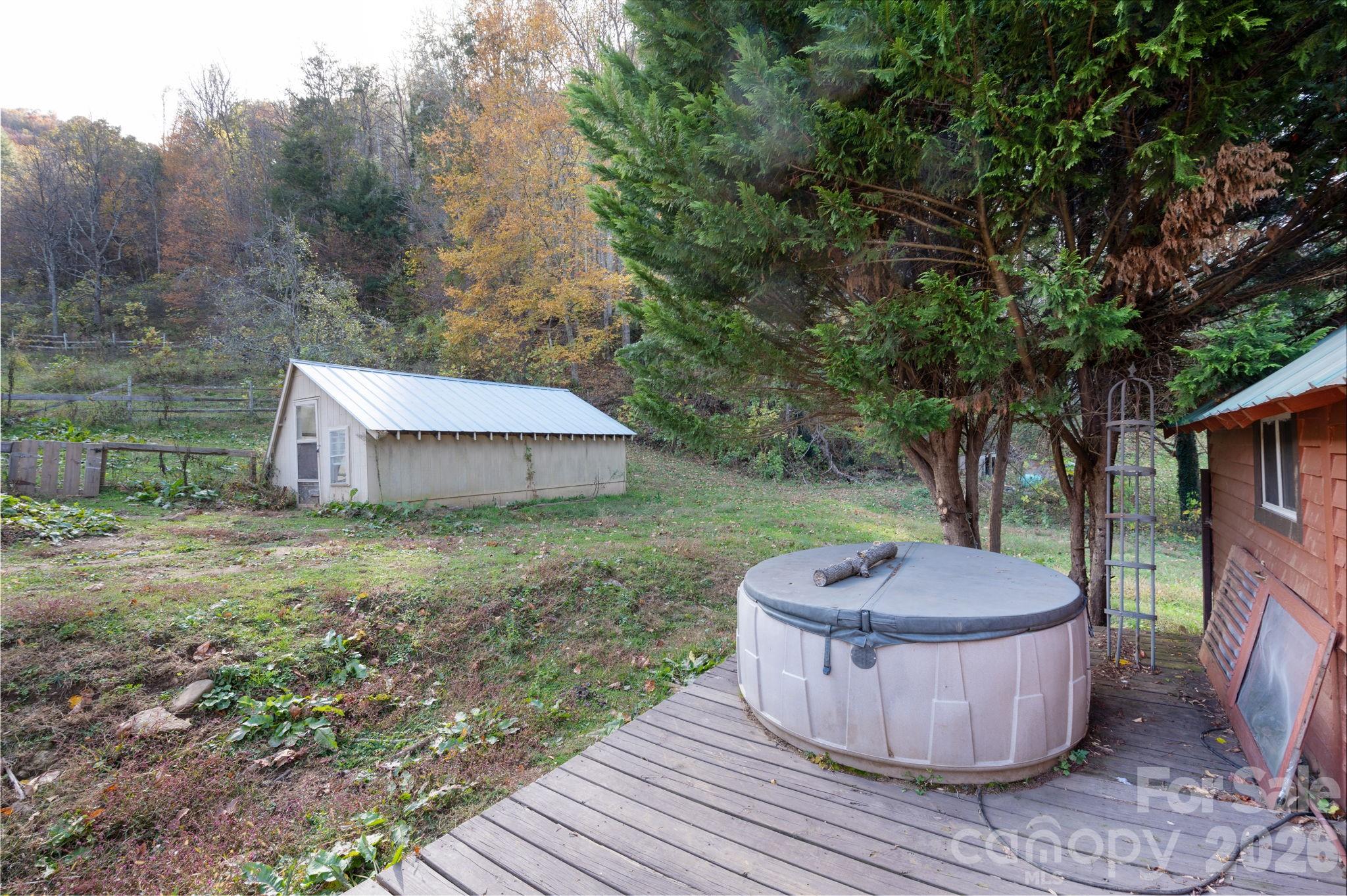1265 Dillingham Road Barnardsville, NC 28709 - Photo 29 of 46 a view of a backyard with table and chairs potted plants and large tree
