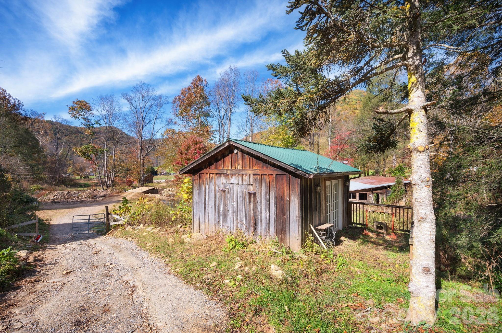 1265 Dillingham Road Barnardsville, NC 28709 - Photo 36 of 46 a view of a house with a small yard and large tree