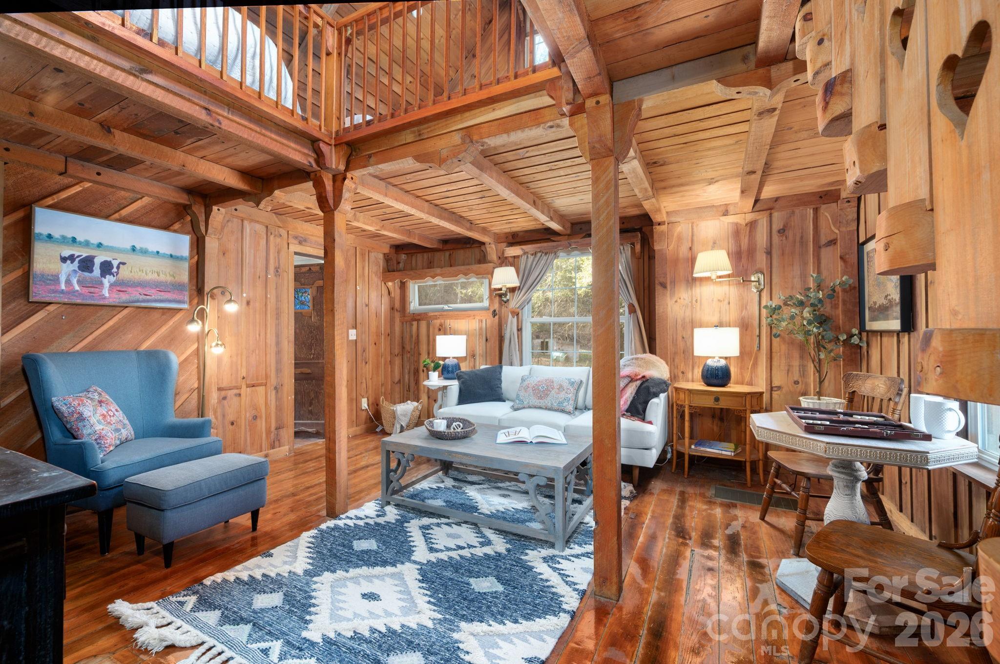 1265 Dillingham Road Barnardsville, NC 28709 - Photo 6 of 46 a living room with furniture and a dining table with wooden floor