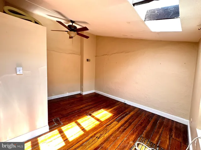 a view of an empty room with closet and a window