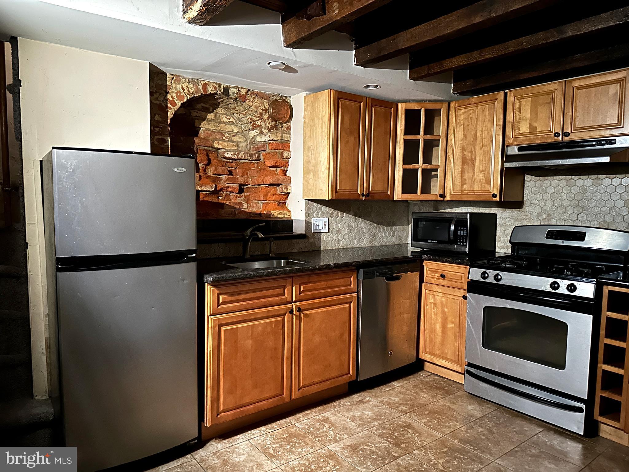 623 South American Street, Unit F Philadelphia, PA 19147 - Photo 30 of 38 a kitchen with stainless steel appliances granite countertop a refrigerator a stove a sink and a microwave
