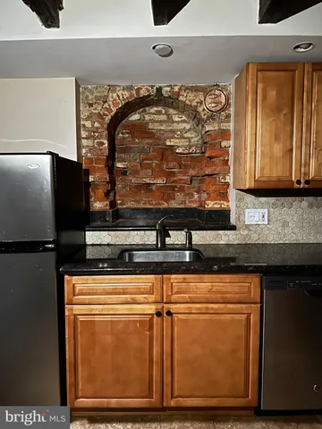 a close view of sink microwave and cabinets