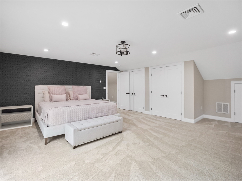 140 Middlesex Street, Unit 3 Lowell, MA 01852 - Photo 18 of 30 a spacious bedroom with a bed and a lamp