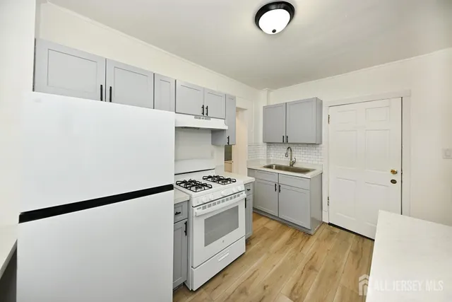 a kitchen with white cabinets and white appliances