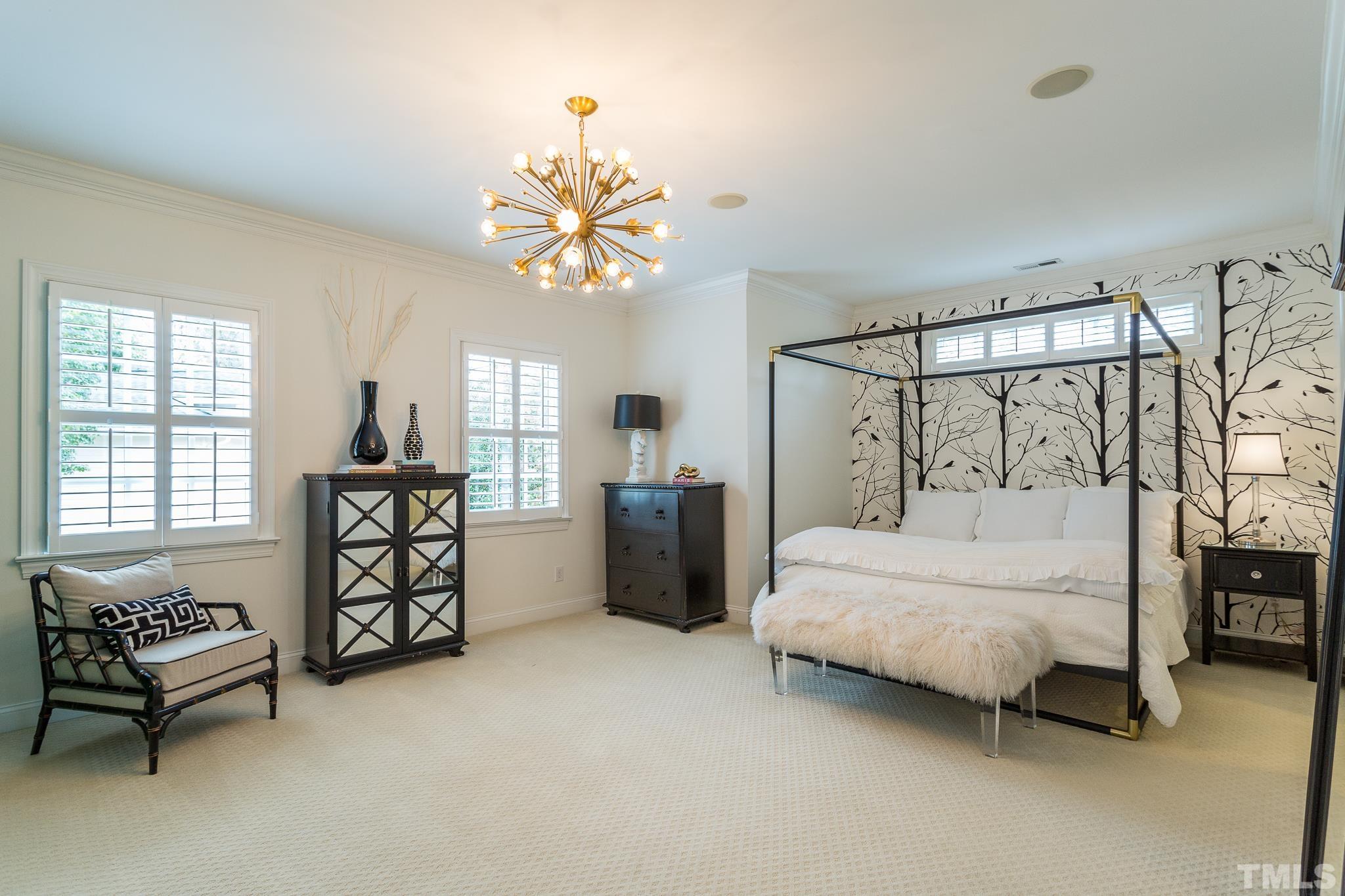 2505 Anderson Drive Raleigh, NC 27608 - Photo 19 of 30 a spacious bedroom with a bed and a chandelier
