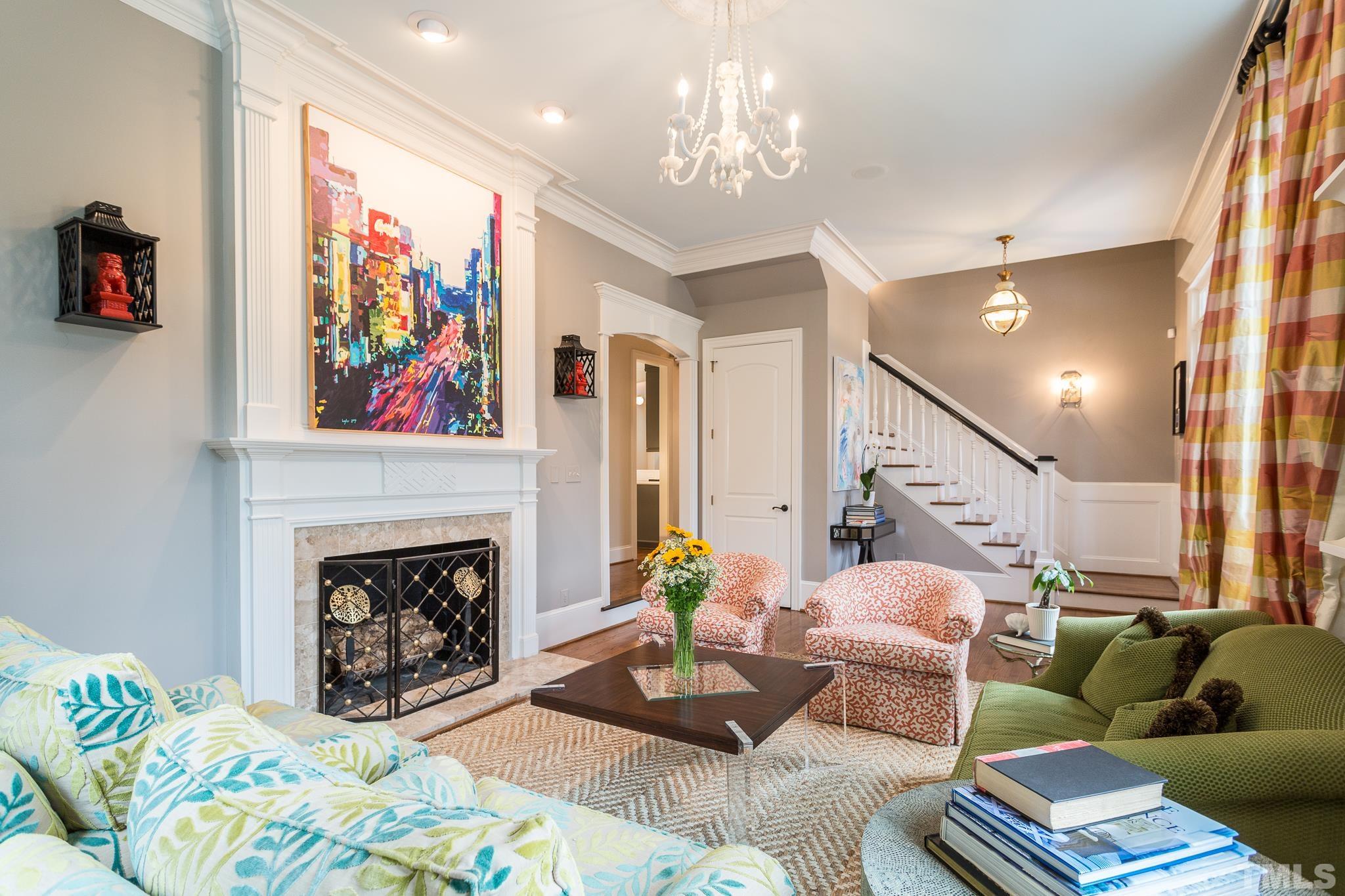 2505 Anderson Drive Raleigh, NC 27608 - Photo 5 of 30 a living room with furniture a fireplace and a chandelier