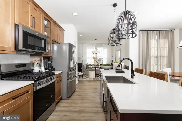 a kitchen with stainless steel appliances a table chairs in it and wooden floors