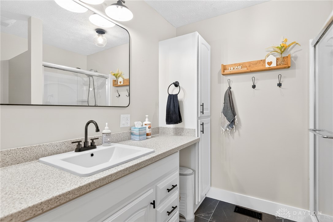 7888 Darke-Preble County Line Road Arcanum, OH 45304 - Photo 33 of 51 This bright bathroom features a vanity, shower, and modern fixtures, creating a clean and inviting space.