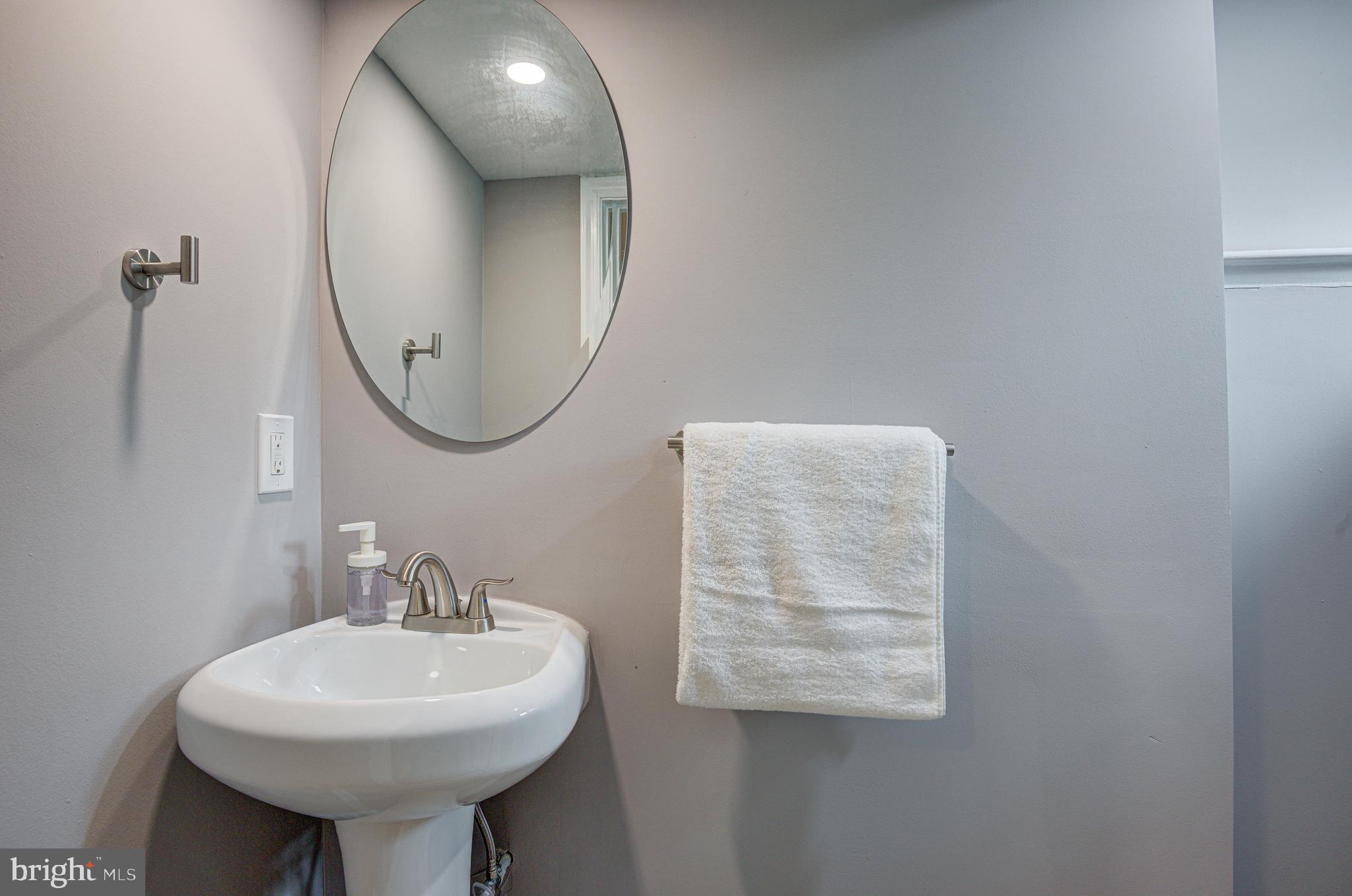 1852 Colmar Road Baltimore, MD 21207 - Photo 25 of 28 a bathroom with a sink a mirror and a toilet
