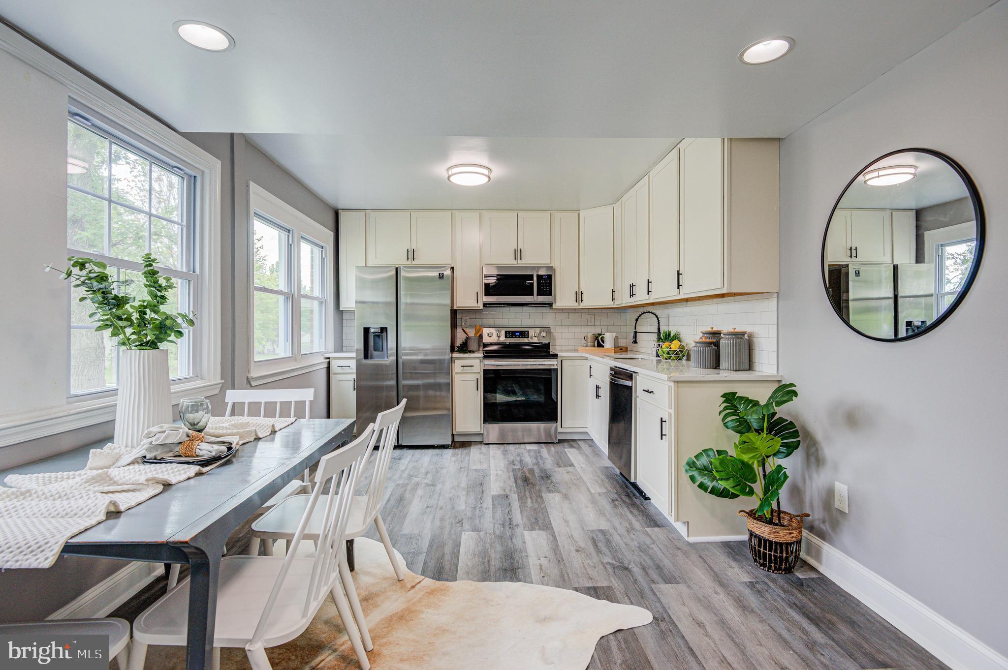 1852 Colmar Road Baltimore, MD 21207 - Photo 4 of 28 a kitchen with a table chairs a center island stainless steel appliances and cabinets