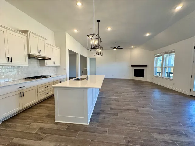 a large kitchen with kitchen island a sink table and chairs