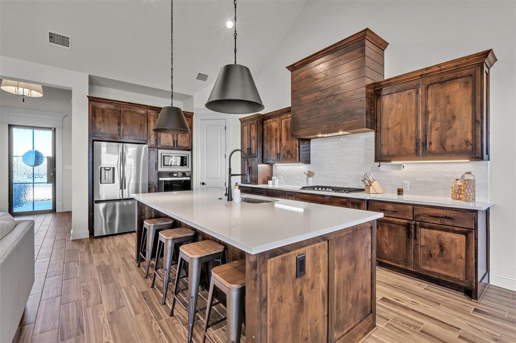 6632 Buffalo Ridge Circle Godley, TX 76044 - Photo 12 of 37 a kitchen with stainless steel appliances granite countertop a sink a stove and a wooden floors
