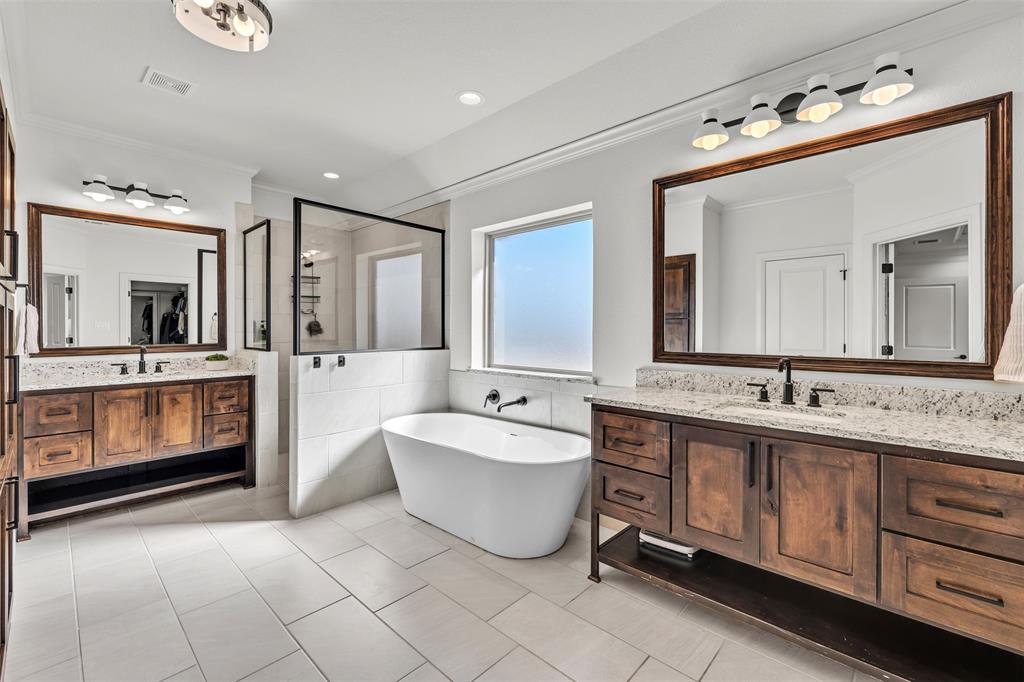 6632 Buffalo Ridge Circle Godley, TX 76044 - Photo 18 of 37 a spacious en suite bathroom with a double vanity sink a mirror and a bathtub
