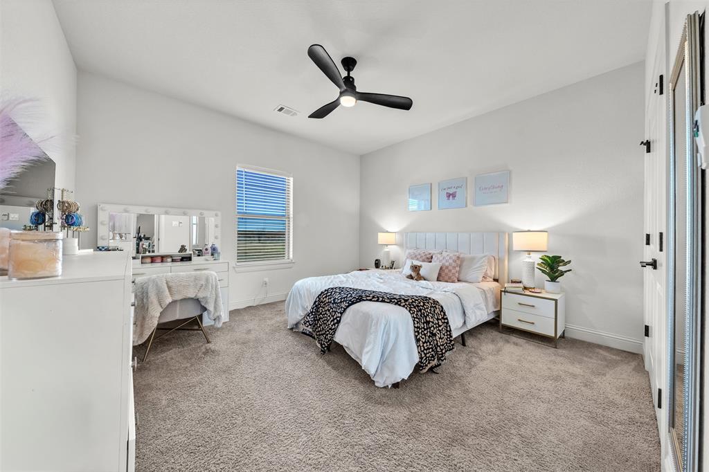 6632 Buffalo Ridge Circle Godley, TX 76044 - Photo 20 of 37 a spacious bedroom with a bed and ceiling fan