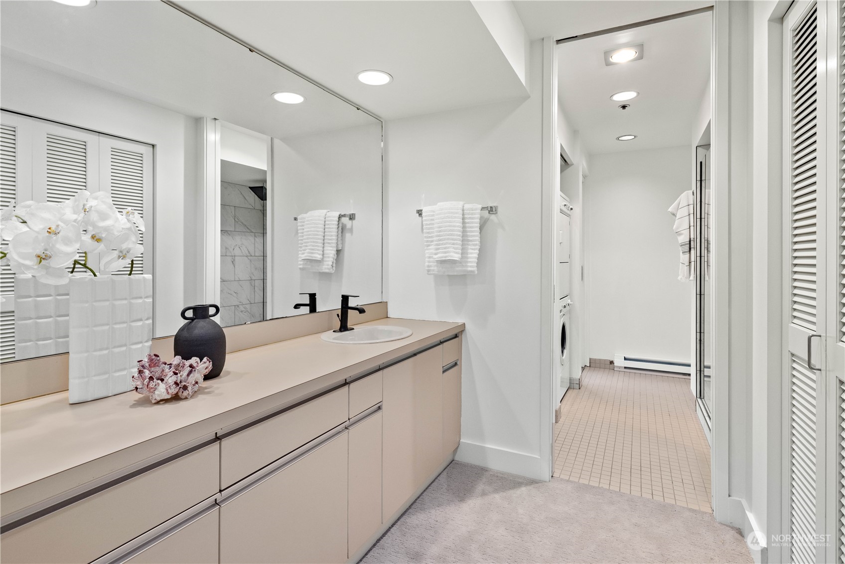 97 South Jackson Street, Unit 507 Seattle, WA 98104 - Photo 19 of 30 a bathroom with a granite countertop sink a mirror and a shower