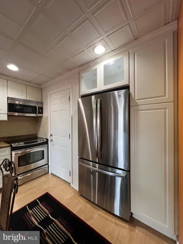 a metallic refrigerator freezer sitting in a kitchen