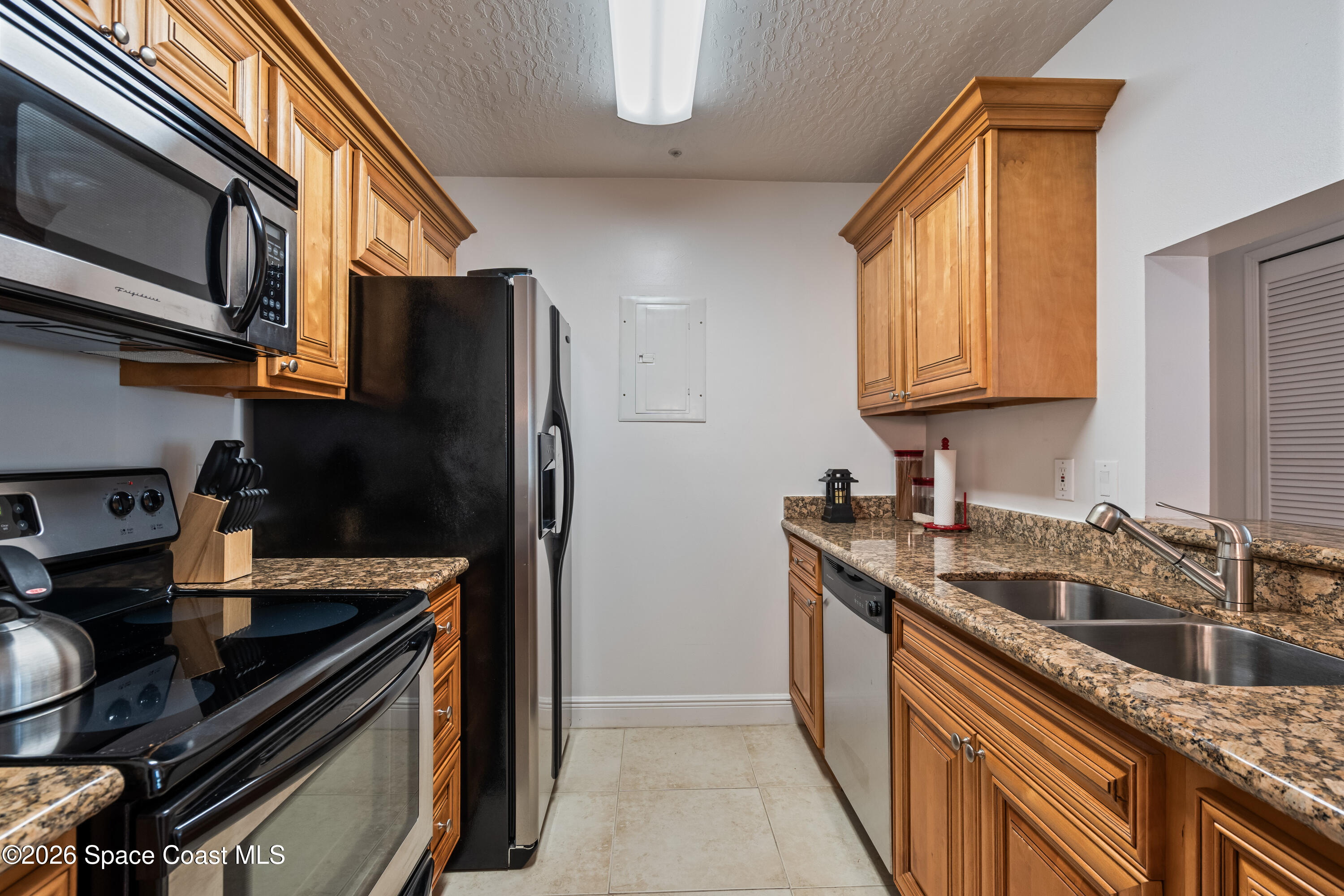 7667 North Wickham Road, Unit 208 Melbourne, FL 32940 - Photo 11 of 33 a kitchen with a sink stove and refrigerator