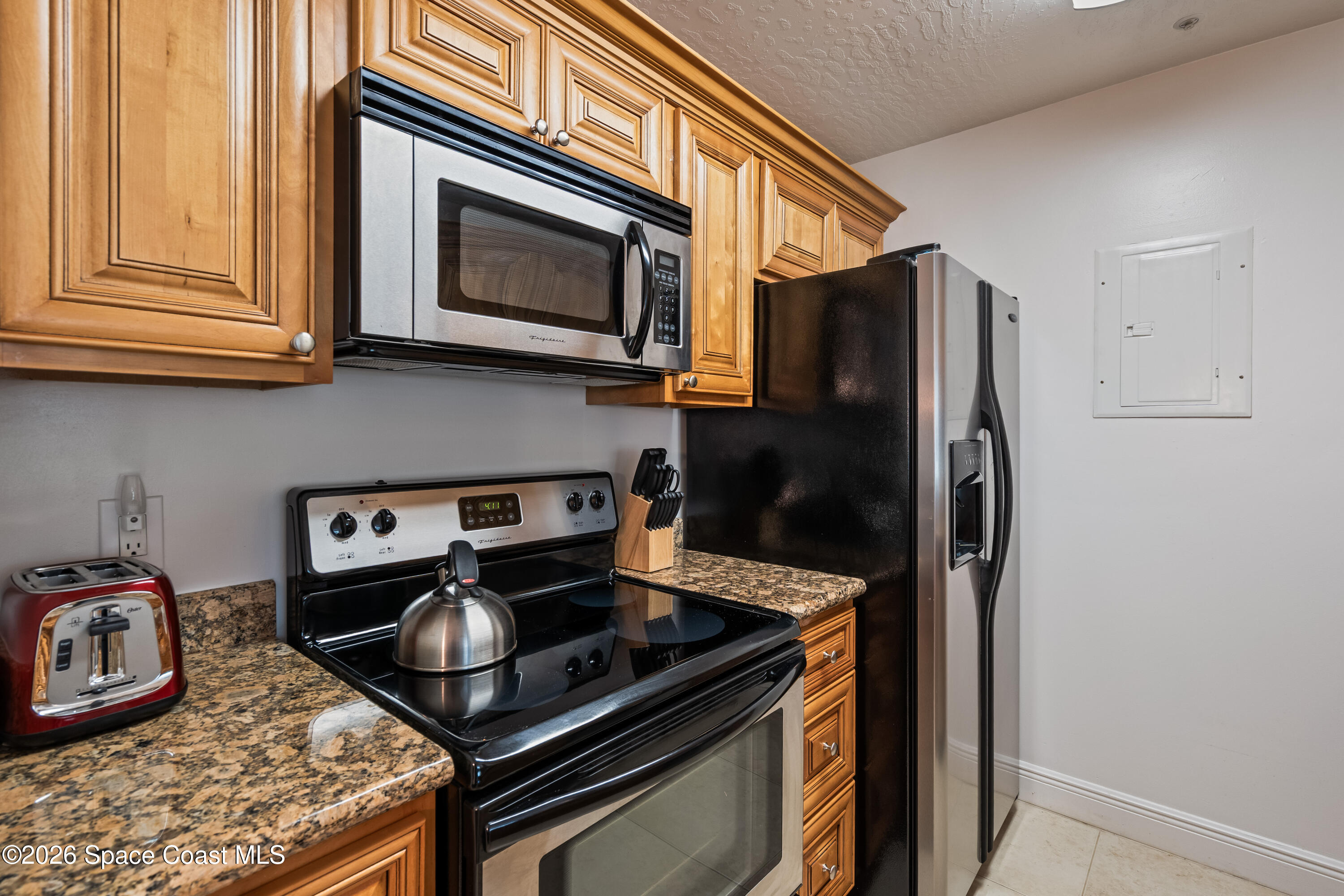 7667 North Wickham Road, Unit 208 Melbourne, FL 32940 - Photo 12 of 33 a kitchen with stainless steel appliances granite countertop a stove and a microwave
