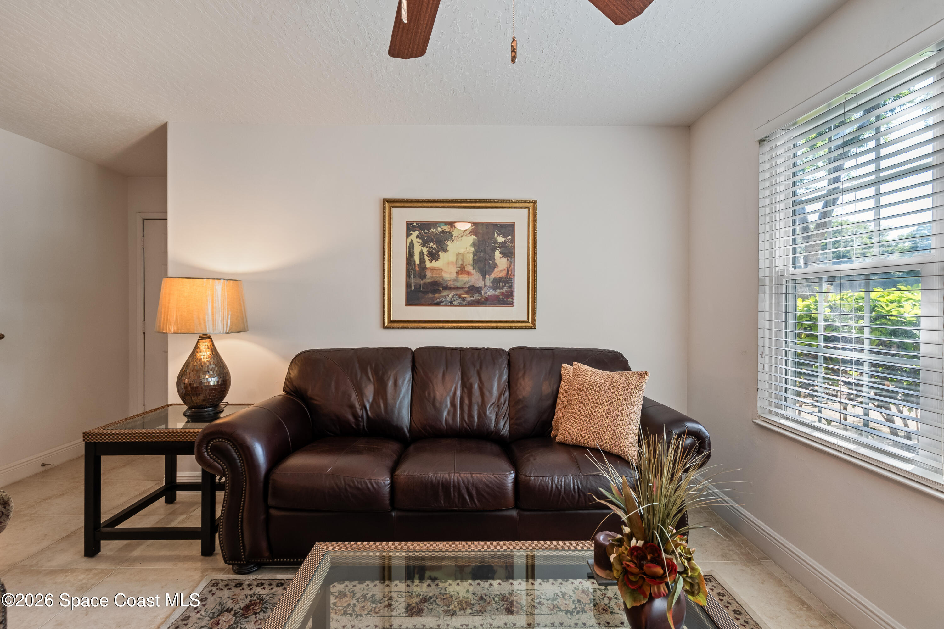 7667 North Wickham Road, Unit 208 Melbourne, FL 32940 - Photo 17 of 33 a blue couch sitting in a living room next to a window