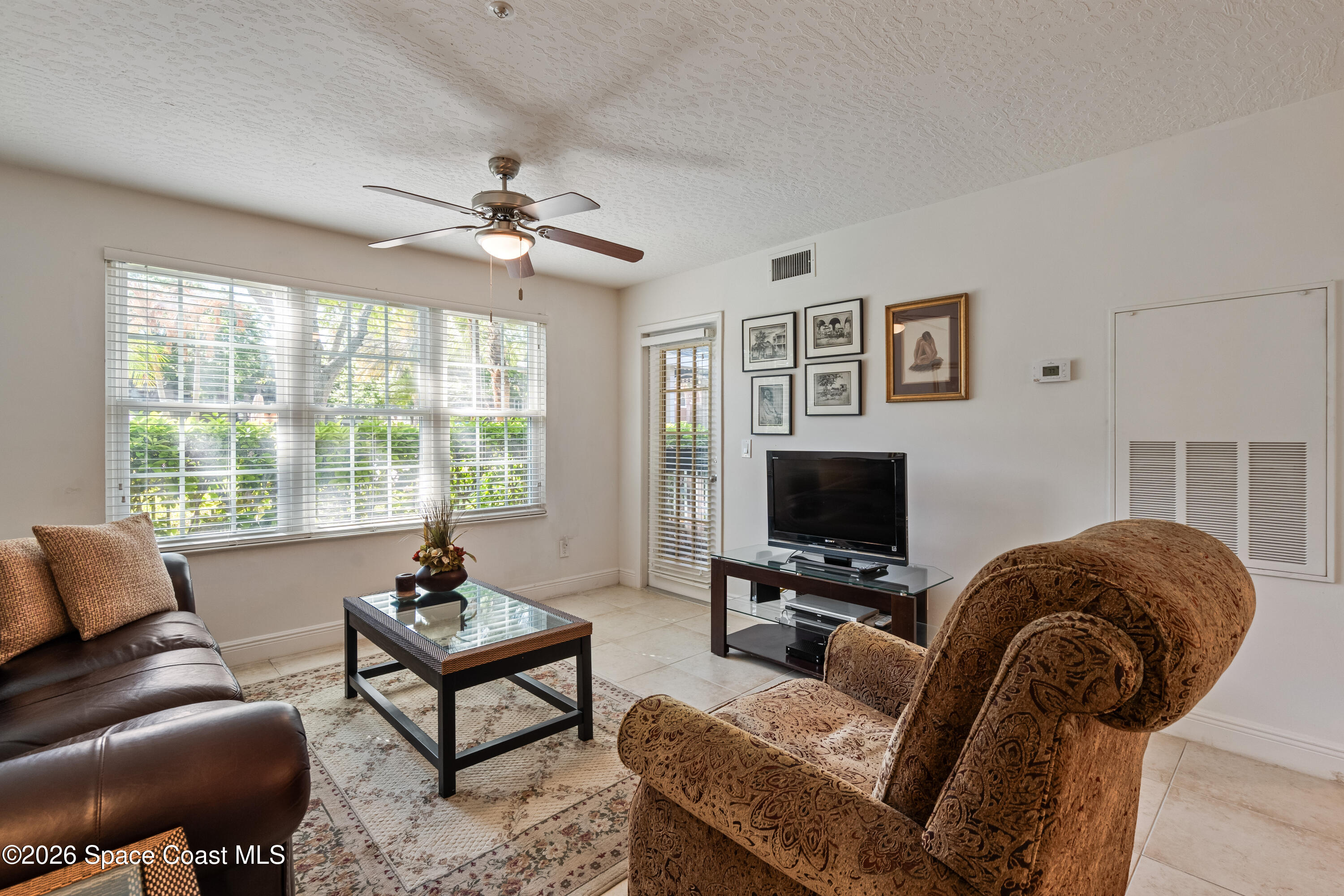 7667 North Wickham Road, Unit 208 Melbourne, FL 32940 - Photo 18 of 33 a living room with furniture and a flat screen tv