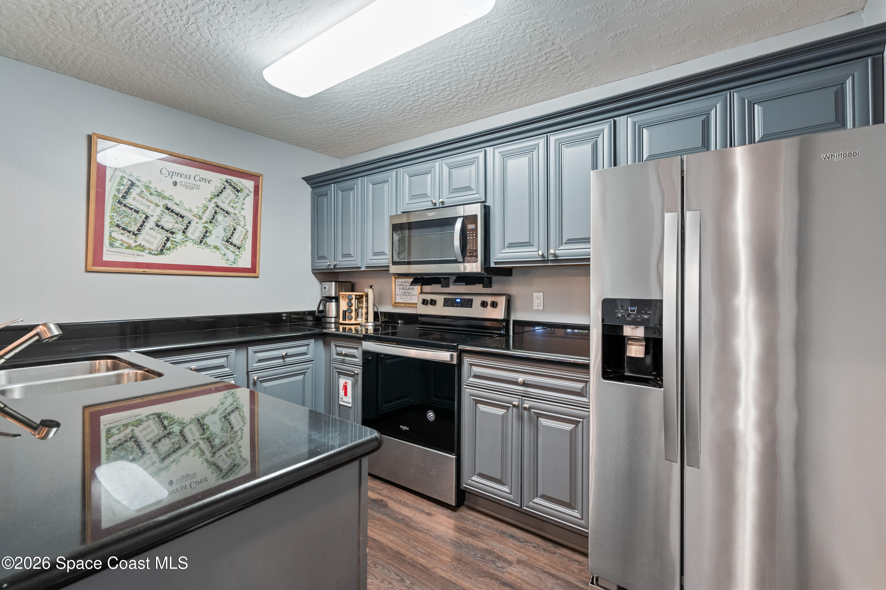 7667 North Wickham Road, Unit 208 Melbourne, FL 32940 - Photo 30 of 33 a kitchen with stainless steel appliances granite countertop a refrigerator stove top oven and sink