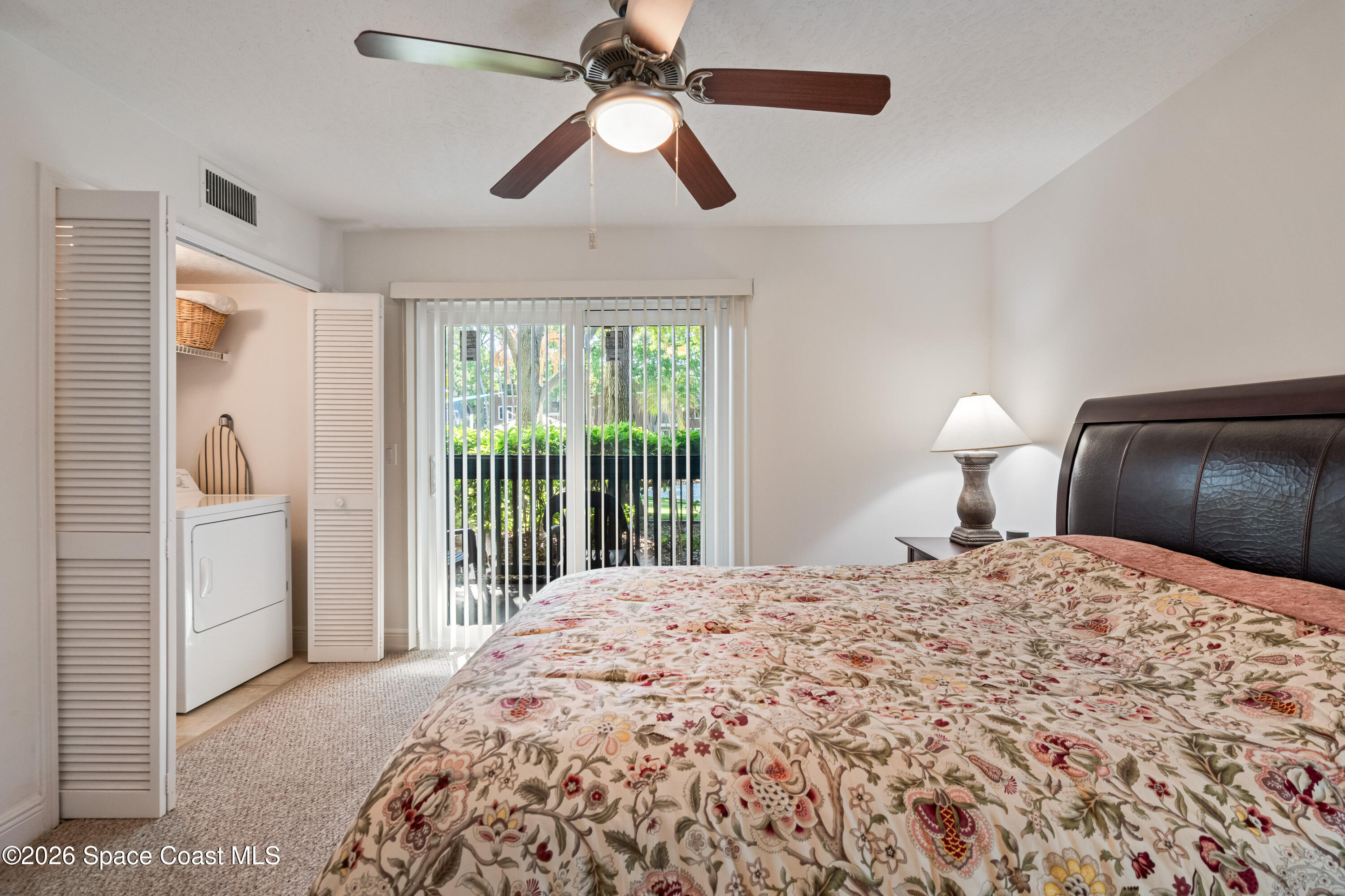 7667 North Wickham Road, Unit 208 Melbourne, FL 32940 - Photo 3 of 33 a bedroom with a large bed and a chandelier