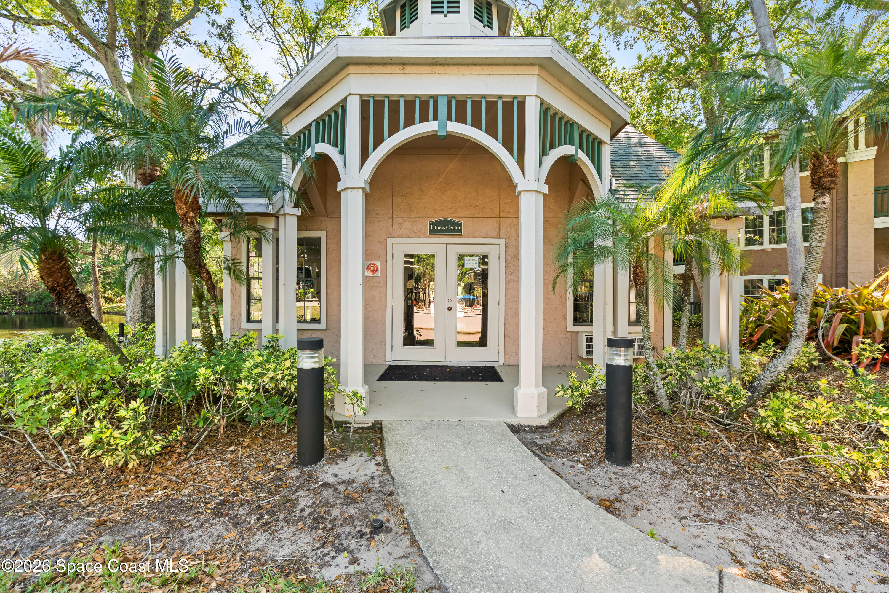 7667 North Wickham Road, Unit 208 Melbourne, FL 32940 - Photo 33 of 33 a view of a brick house with a large windows and flower plants