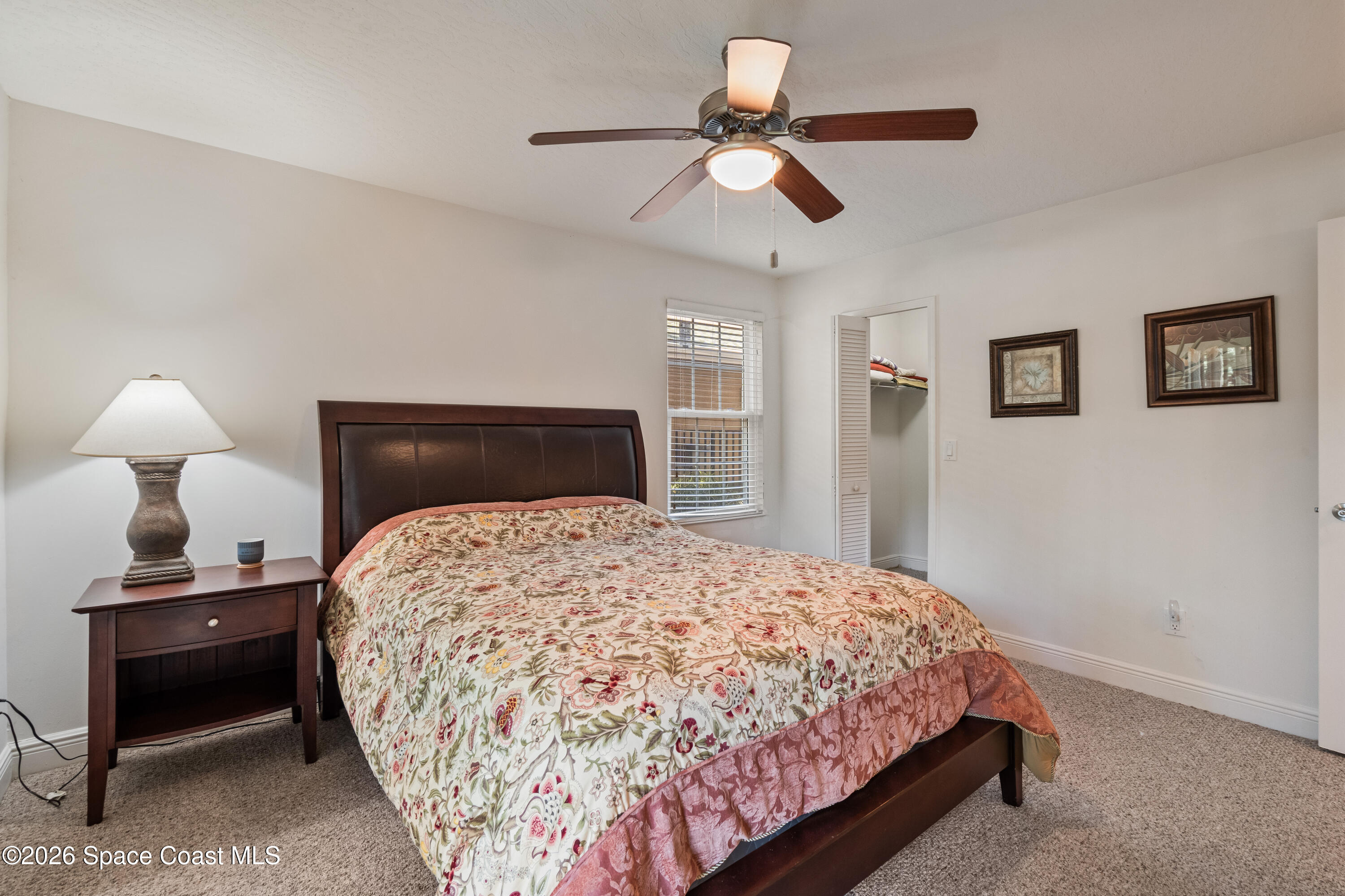 7667 North Wickham Road, Unit 208 Melbourne, FL 32940 - Photo 7 of 33 a bedroom with a bed and a chandelier
