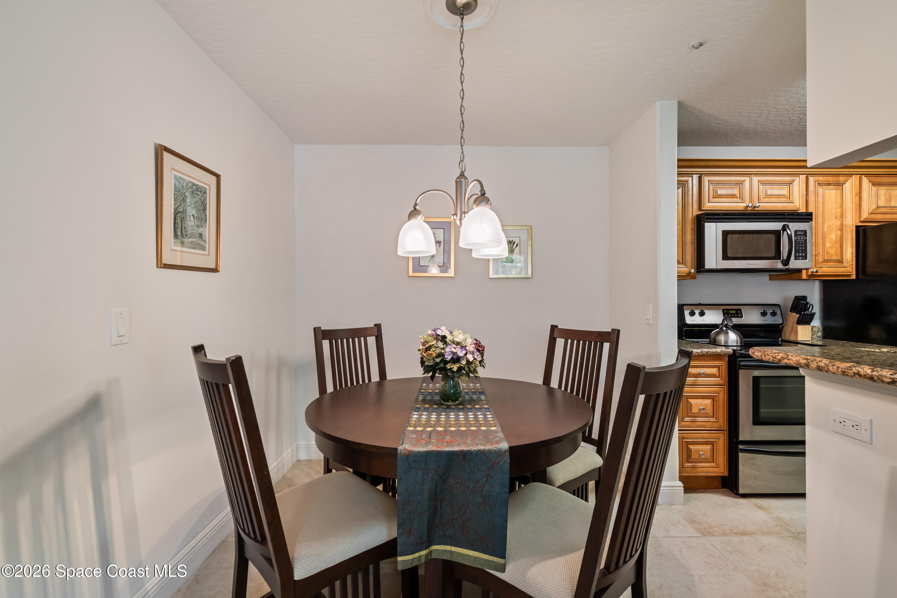 7667 North Wickham Road, Unit 208 Melbourne, FL 32940 - Photo 9 of 33 a view of a dining room with furniture a chandelier and wooden floor